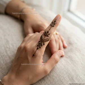 Easy finger mehndi design featuring tiny leaves and evenly spaced dots arranged in a delicate vertical trail