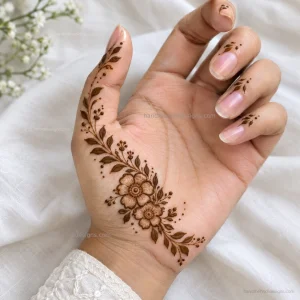 Half palm mehndi featuring a small side floral cluster, leafy branch, and scattered dots near the thumb.