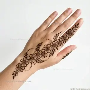 Back hand with tiny flowers and leafy trails arranged diagonally in a simple mehndi pattern
