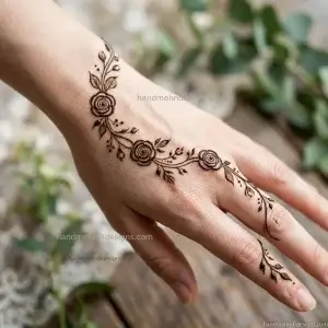 Rose vine bel mehndi on the back hand with miniature spiral roses and delicate leafy branches.
